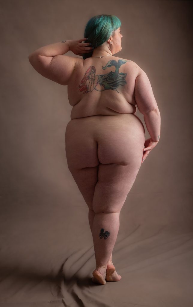 “Fine-art portrait of a client standing tall on tiptoe, captured in soft studio light for an uplifting, graceful mood.”